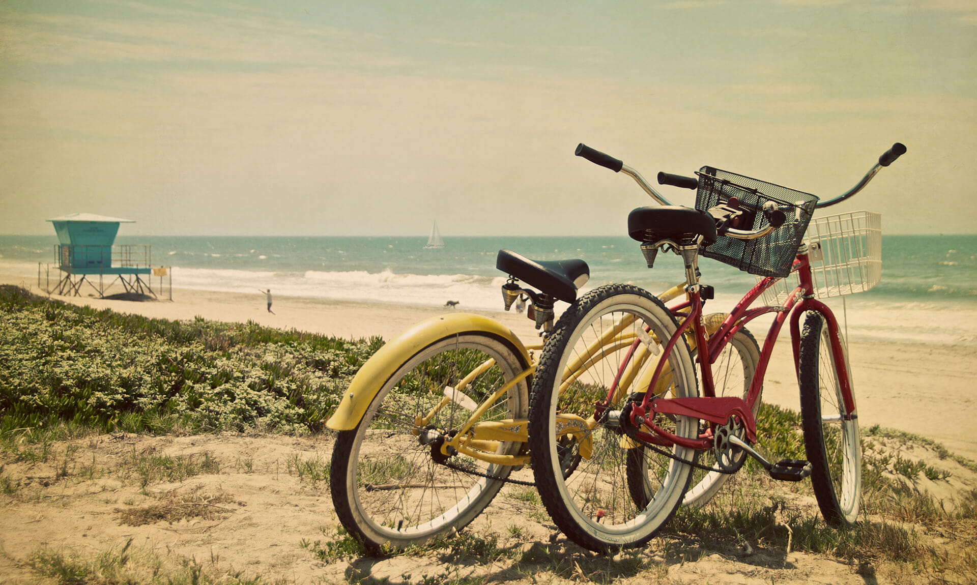 Yellow and red bikes on sand.